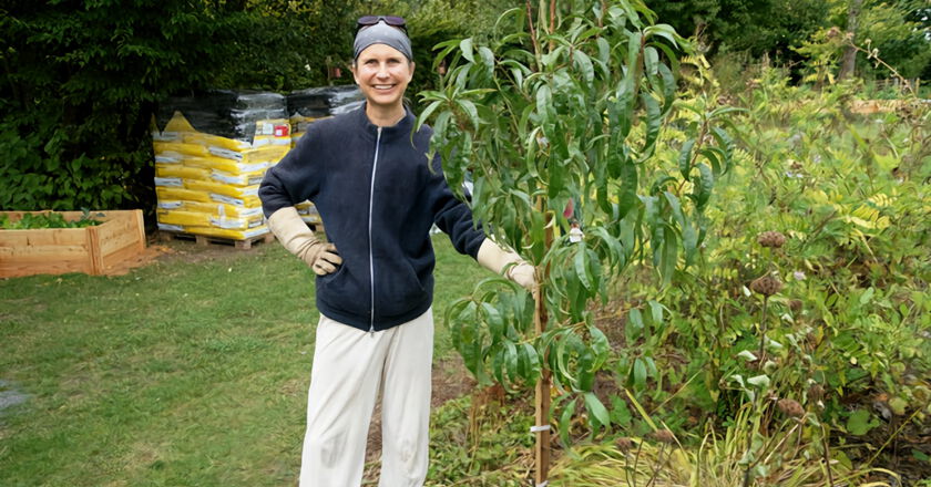 Projektleiterin Alexandra Walterskirchen mit neu gepflanztem Pfirsichbaum